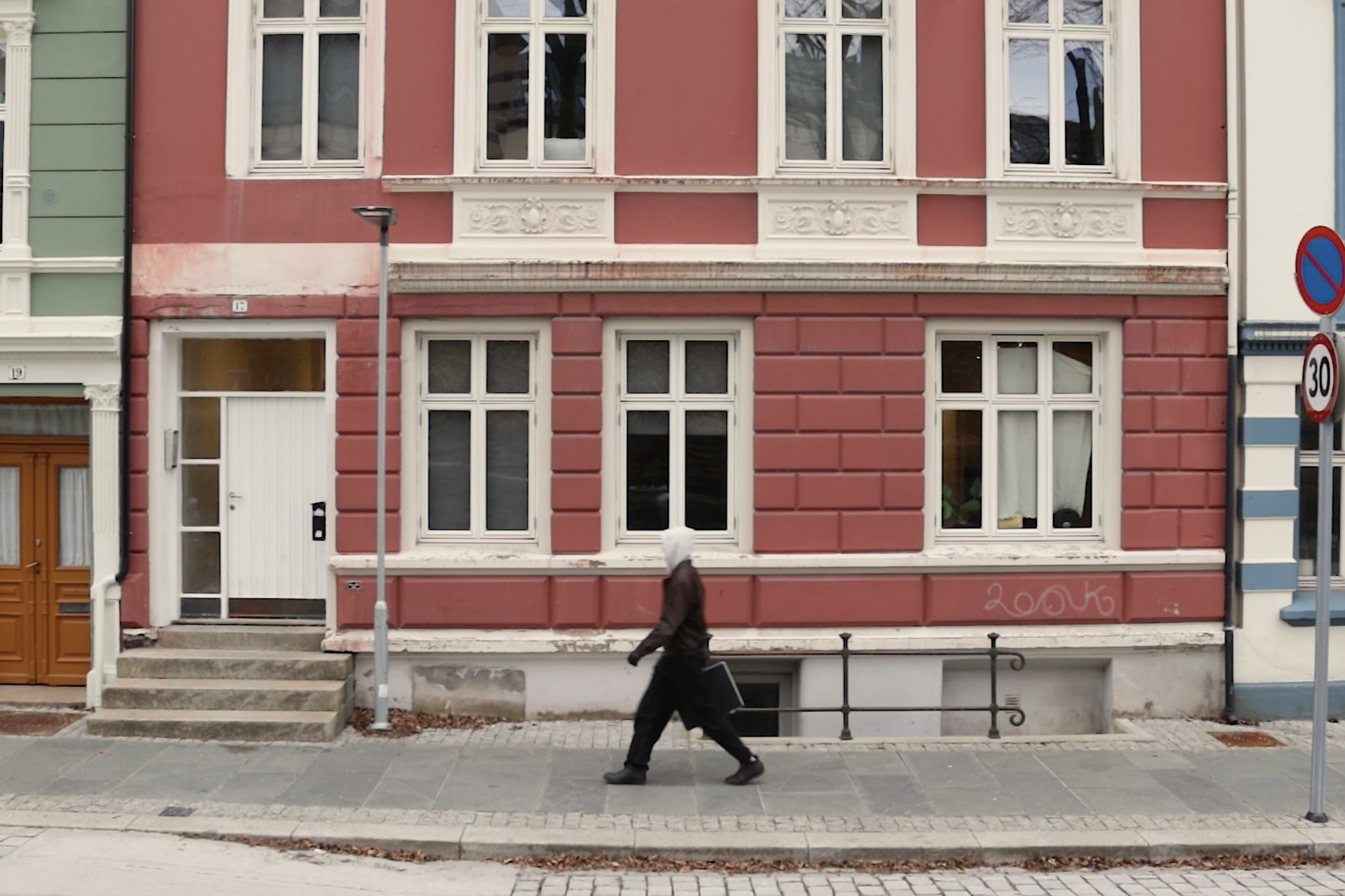 En person som går foran en bygning